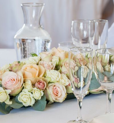 Klassisk borddekorasjon med roser i fersken og rosa